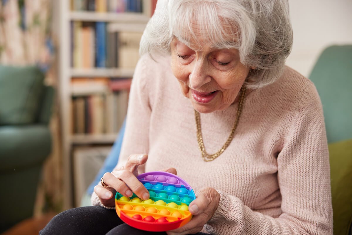 Senior woman stimulating senses with a colorful toy