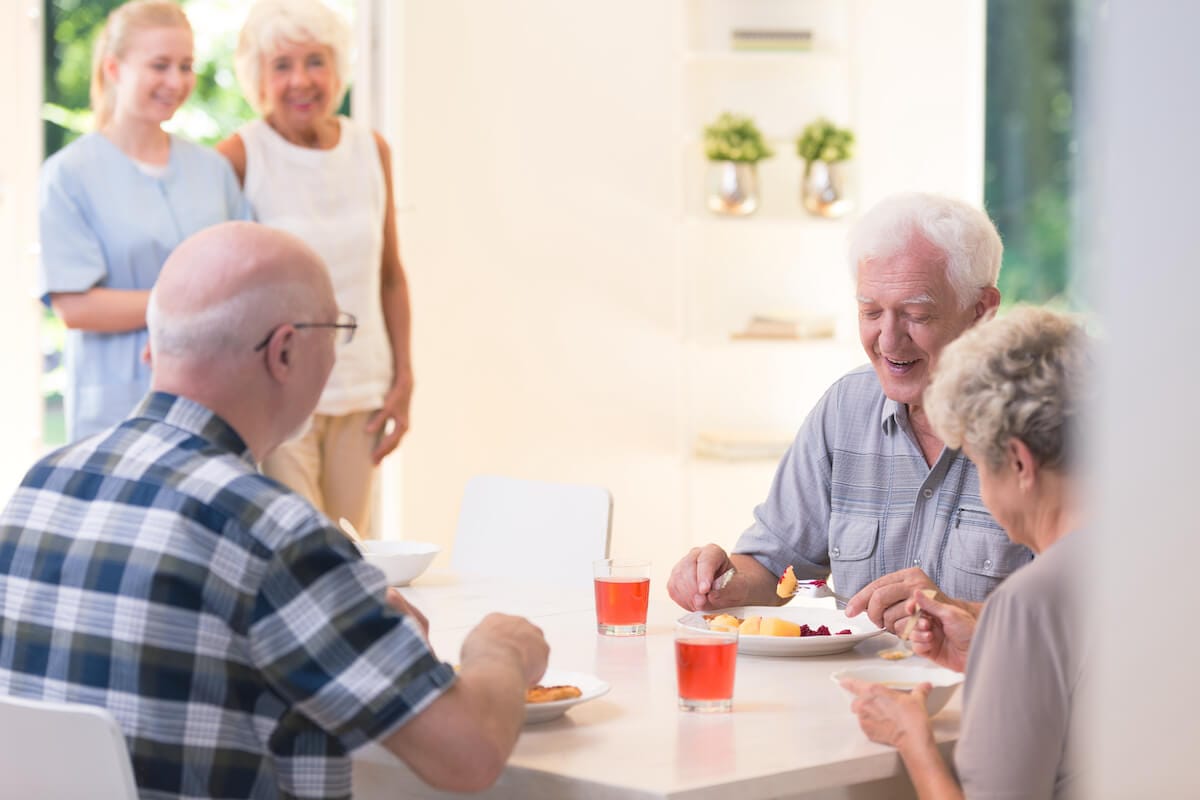 Group of seniors eating together in a senior living community