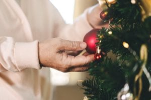 Senior's hand grabbing a Christmas sphere.