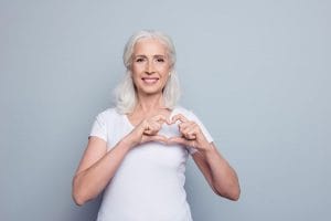 Older woman making a heart sign with her hands